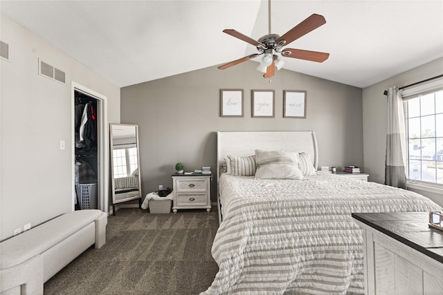 bedroom with a spacious closet, visible vents, ceiling fan, vaulted ceiling, and carpet floors