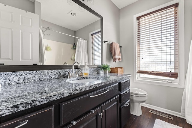 bathroom featuring visible vents, toilet, wood finished floors, baseboards, and vanity