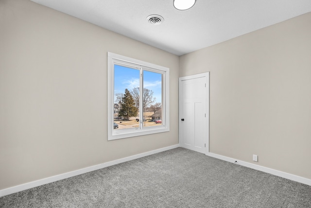 spare room with visible vents, baseboards, and carpet