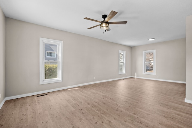 unfurnished room featuring visible vents, baseboards, a ceiling fan, and wood finished floors