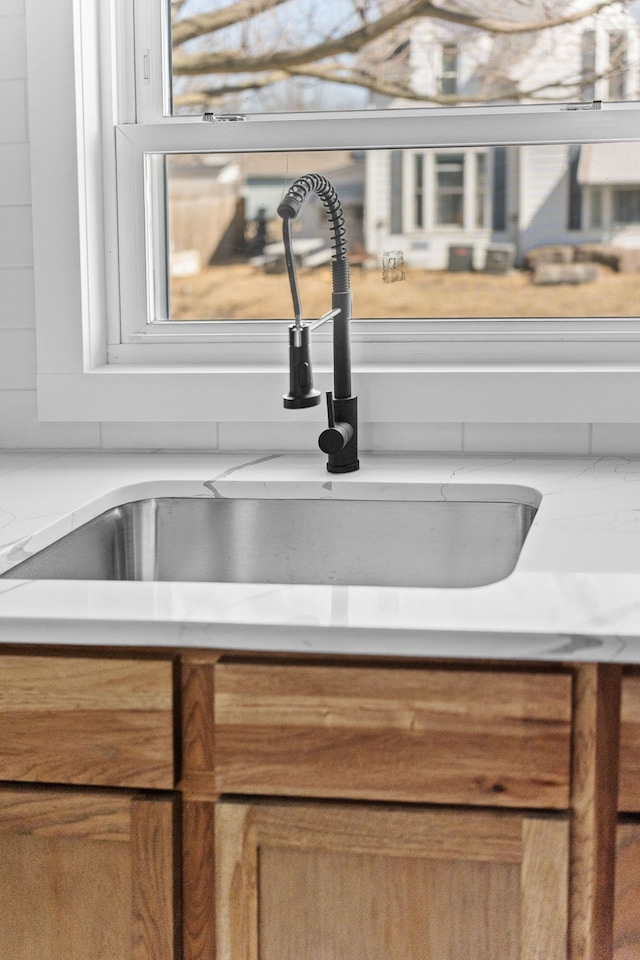 room details with brown cabinetry, light countertops, and a sink