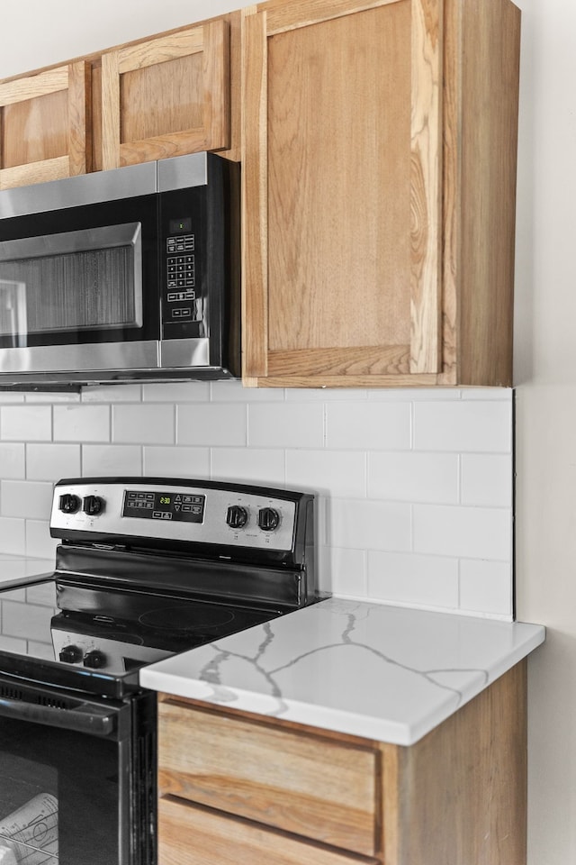 kitchen with tasteful backsplash, stainless steel appliances, and light stone counters