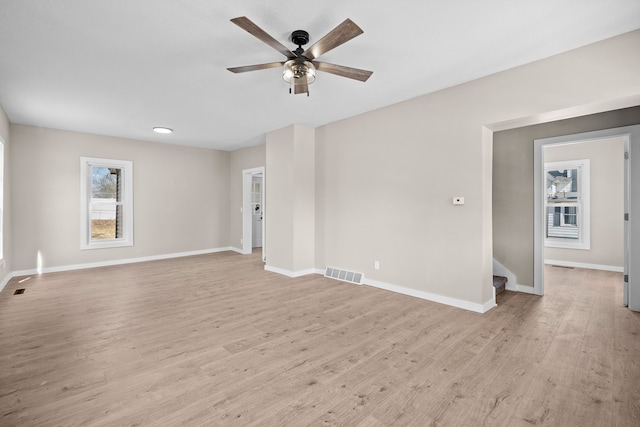 interior space featuring light wood-style flooring, baseboards, visible vents, and ceiling fan