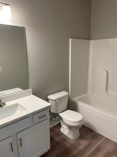 bathroom featuring vanity, toilet, and wood finished floors