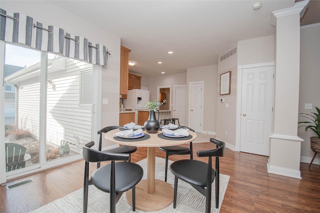 dining area featuring wood finished floors, visible vents, and baseboards