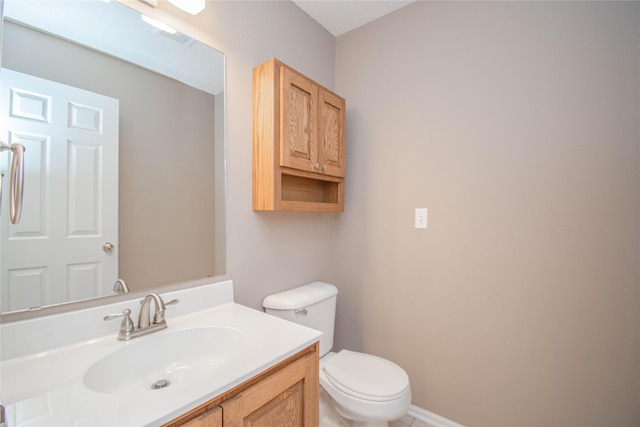 bathroom with visible vents, baseboards, toilet, and vanity