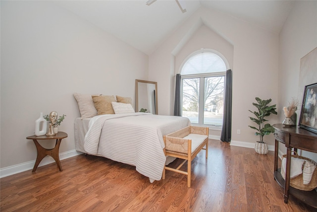 bedroom with baseboards, wood finished floors, and vaulted ceiling