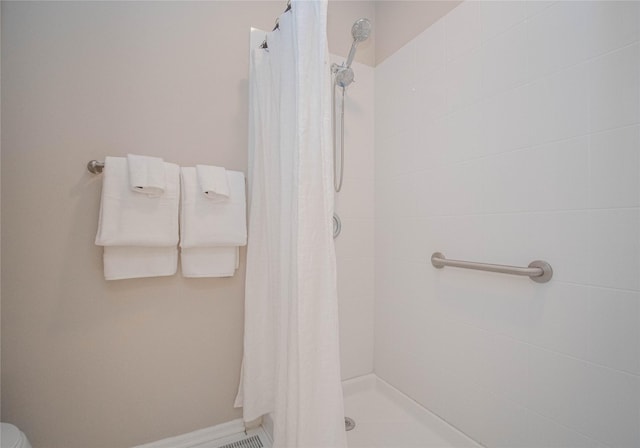 full bathroom featuring baseboards and a stall shower