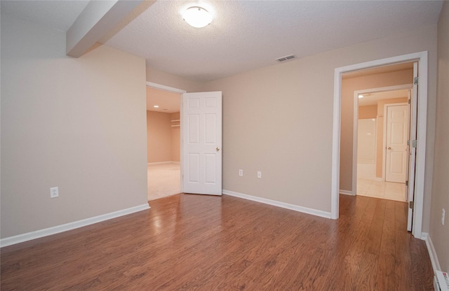 spare room with visible vents, baseboards, baseboard heating, and wood finished floors