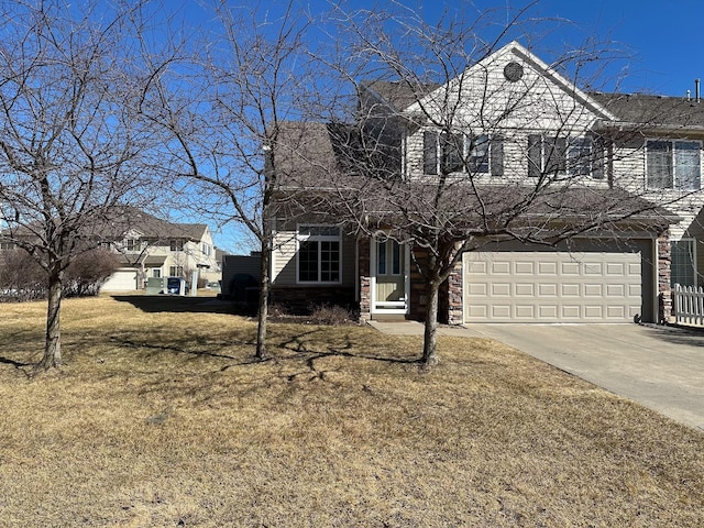 view of front of property with a front lawn, stone siding, a garage, and driveway