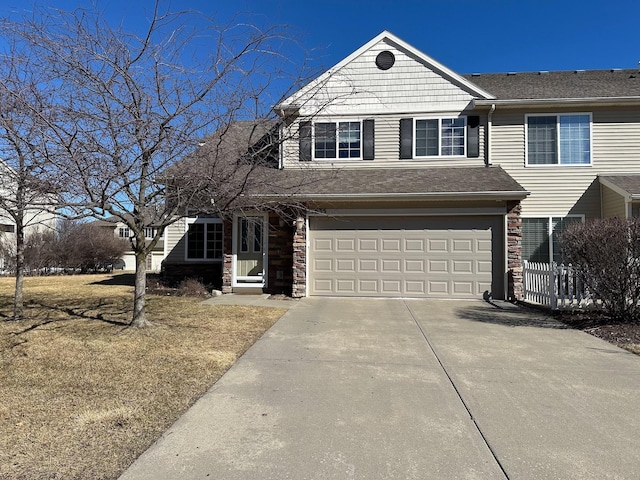 view of front facade with stone siding, concrete driveway, and a garage