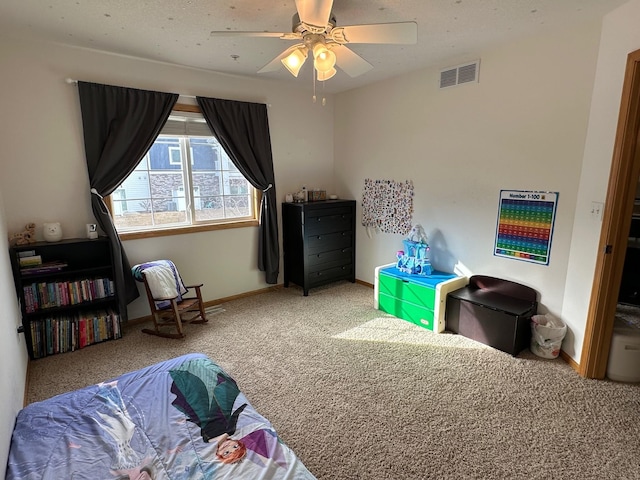 carpeted bedroom featuring visible vents, baseboards, and ceiling fan