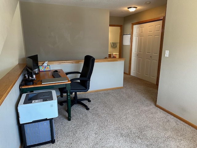 carpeted office space featuring baseboards and a textured ceiling