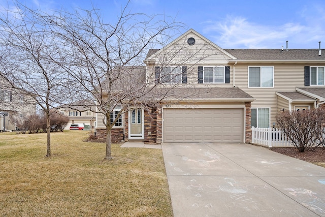 view of front facade featuring stone siding, a garage, driveway, and a front yard