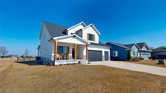 modern farmhouse with driveway, covered porch, a front lawn, a garage, and board and batten siding