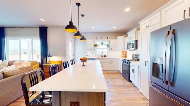 kitchen featuring light wood finished floors, recessed lighting, appliances with stainless steel finishes, and a sink