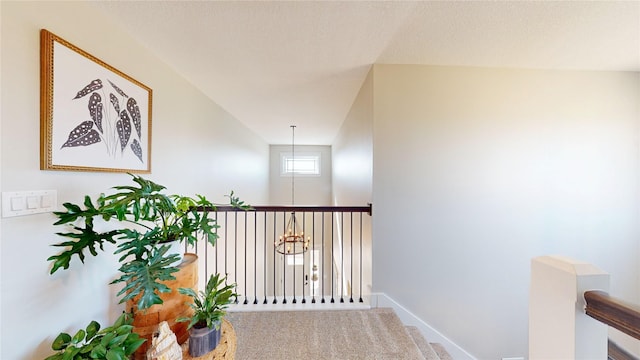 hallway featuring carpet and baseboards