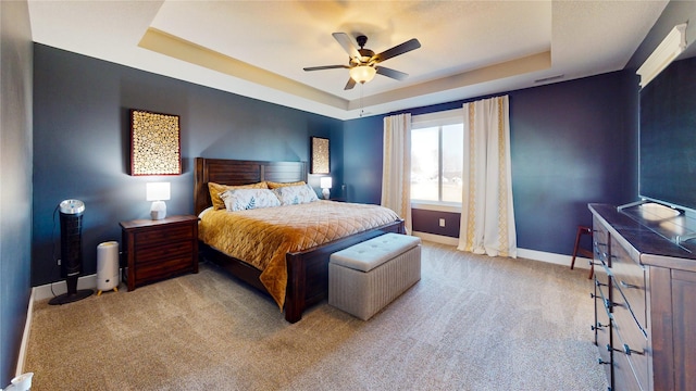 carpeted bedroom featuring a raised ceiling, a ceiling fan, baseboards, and visible vents