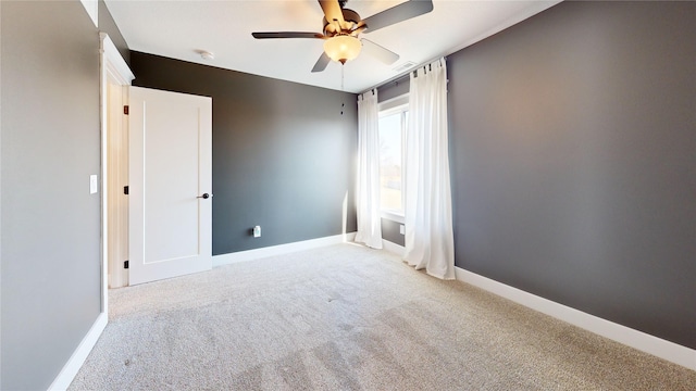 empty room featuring carpet flooring, ceiling fan, and baseboards