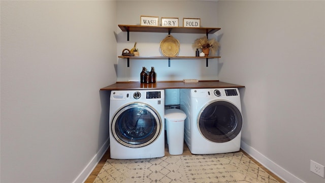 washroom featuring laundry area, washer and dryer, and baseboards