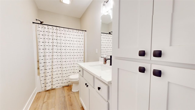 bathroom featuring toilet, vanity, and hardwood / wood-style flooring