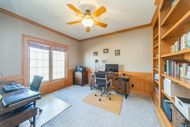 home office with a wainscoted wall, visible vents, ceiling fan, and ornamental molding