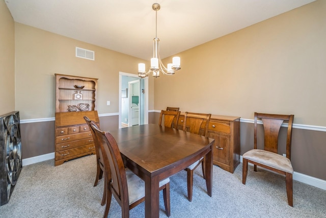 dining space featuring a chandelier, visible vents, light colored carpet, and baseboards