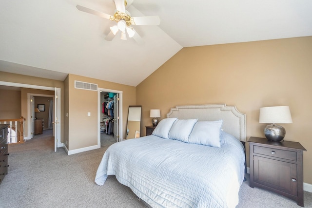 bedroom with a spacious closet, visible vents, baseboards, light colored carpet, and vaulted ceiling