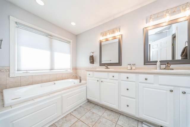 bathroom with a garden tub, double vanity, recessed lighting, a sink, and tile patterned floors