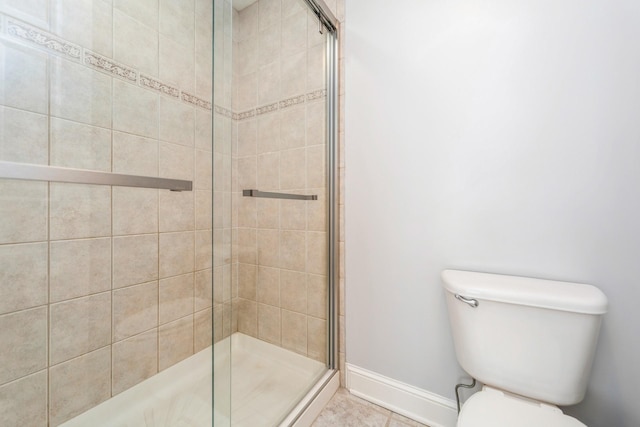 bathroom with toilet, baseboards, and a stall shower