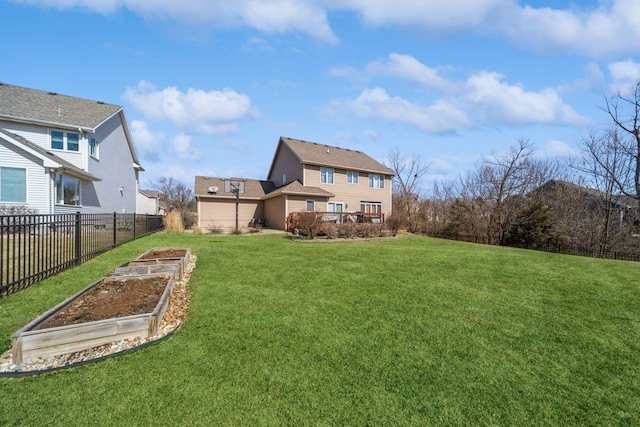 rear view of property with a vegetable garden, a lawn, and fence