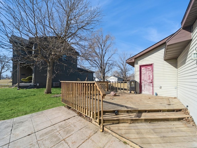 wooden deck featuring a lawn and a patio