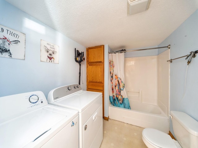 laundry room with washer and dryer, visible vents, a textured ceiling, and laundry area