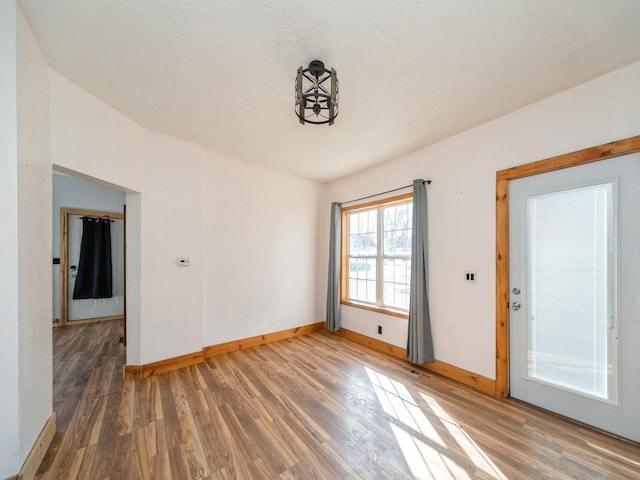 spare room featuring visible vents, baseboards, and wood finished floors