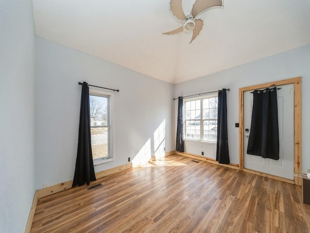 unfurnished bedroom with lofted ceiling, wood finished floors, visible vents, and ceiling fan