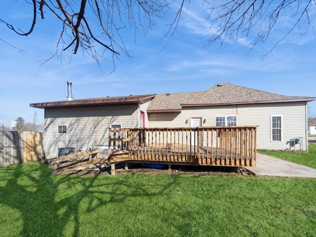 back of house featuring a deck, roof with shingles, a yard, and fence