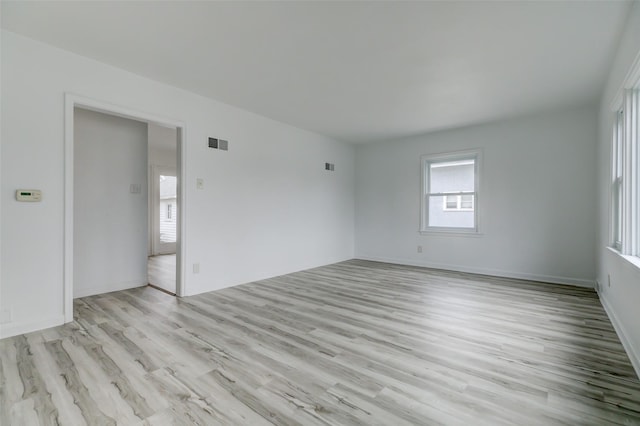 empty room featuring light wood finished floors and visible vents