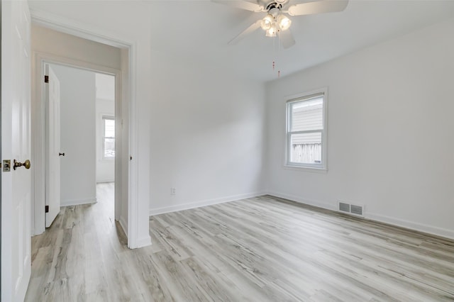 empty room with visible vents, ceiling fan, baseboards, and light wood-style floors