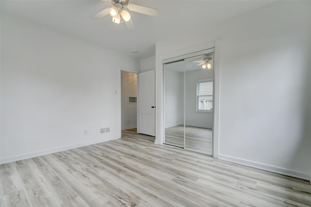 unfurnished bedroom featuring visible vents, a ceiling fan, a closet, light wood finished floors, and baseboards