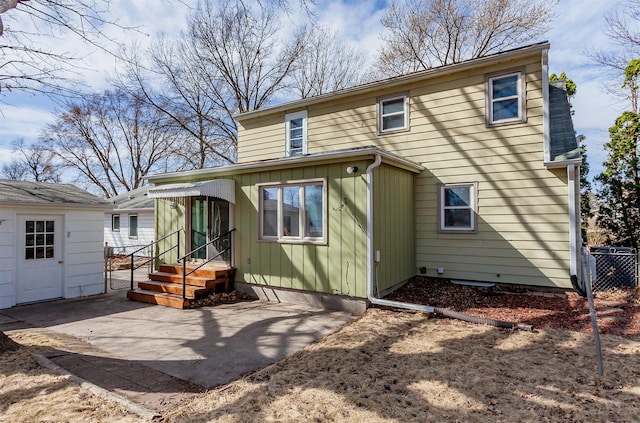 rear view of house with board and batten siding and fence