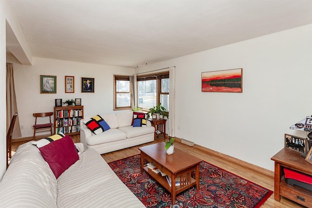 living area featuring baseboards and wood finished floors