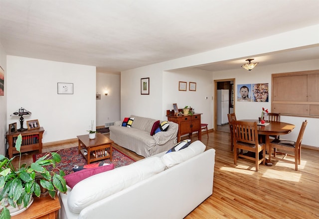 living area featuring visible vents, light wood-type flooring, and baseboards