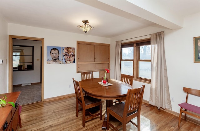 dining space with light wood finished floors and baseboards