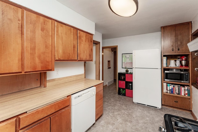 kitchen featuring white appliances, brown cabinetry, and light countertops