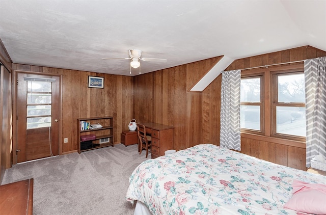 carpeted bedroom with wood walls and a ceiling fan