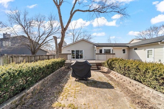 rear view of property with a wooden deck and fence