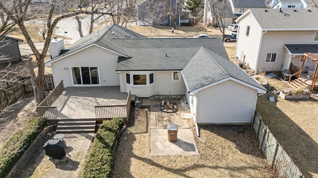 back of property with a wooden deck, roof with shingles, and a fenced backyard