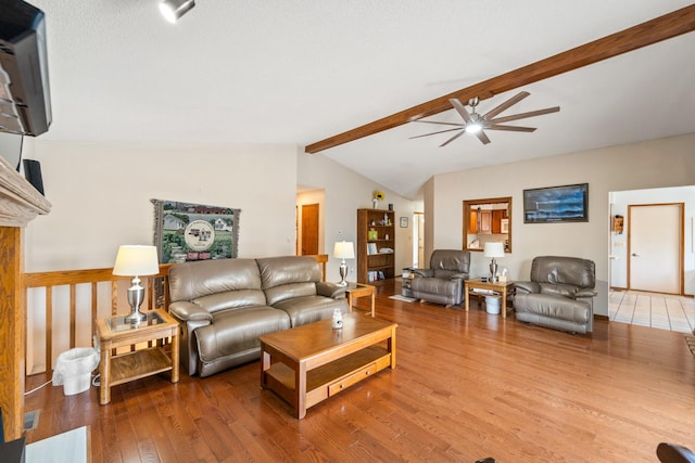 living room featuring vaulted ceiling with beams, wood finished floors, visible vents, and ceiling fan