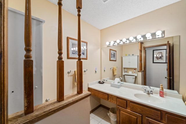 bathroom featuring tile patterned floors, toilet, a textured ceiling, and vanity