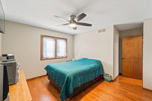 bedroom featuring visible vents, ceiling fan, light wood-type flooring, and baseboards